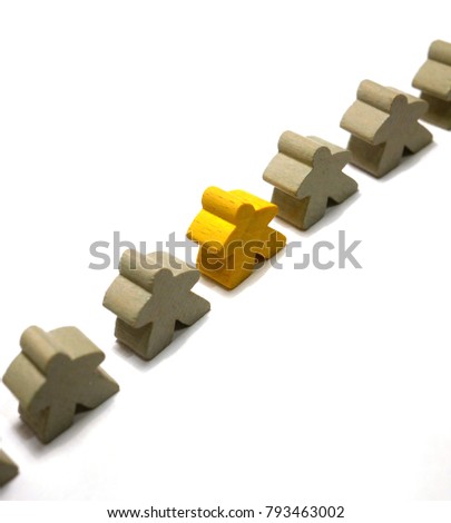Be different concept: Yellow wooden miniperson in middle of line of grey mini people