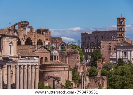 Forum of Caesar in Rome, Italy. Architecture and landmark of Rome. Bright sunny day. Beautiful aerial view from the Capitoline Hill. Colosseum and Basilica of Maxentius on background.