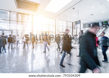trade fair visitors walking in a clean futuristic corridor