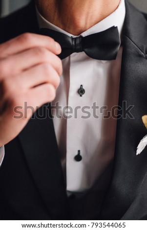 Close up of bowtie. Man in black costume and white Shirt.