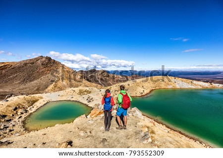 New Zealand popular tourist hiking hike in Tongariro Alpine Crossing National Park. Tramping trampers couple hikers walking on famous destination in NZ. Royalty-Free Stock Photo #793552309