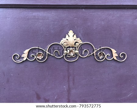 Beautiful metal adornment mounted on purple wooden backdrop
