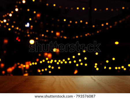 blur orange yellow party light in the dark night bar or pub with top of wood table background
