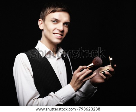  Young male make up artist posing  with foundation for make-up o