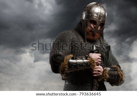 Warrior Viking in full arms with axe and helmet on dark background Royalty-Free Stock Photo #793636645