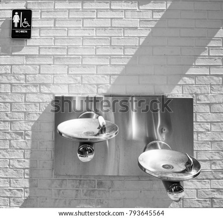  water fountain and women restroom in black and white.