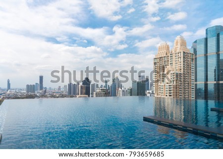 Swimming pool on top of building with city scape skyline view with blue sky and cloud. Business district center in downtown. Picture for add text message. Backdrop for design art work.