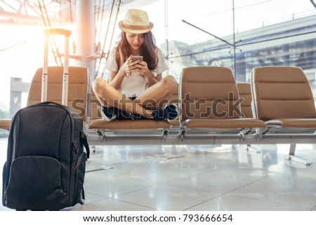 Asian teenage girl is using a smartphone to check flight at the international airport to travel on weekends. Royalty-Free Stock Photo #793666654