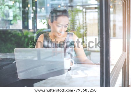 Business woman working with a laptop computer and writing notebook in the office.