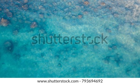 Aerial view of the transparent ocean, rocks and reef