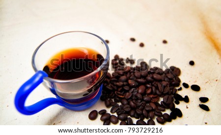 soft focus of a cup of energetic drink infusion and coffee beans with a raw background. for detox and healthy concept