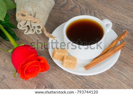 red rose with coffee cup on wooden table