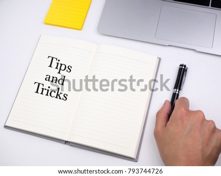 Tips and tricks on note book with hand on desk
