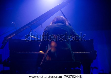 Pianist is playing piano in concert.