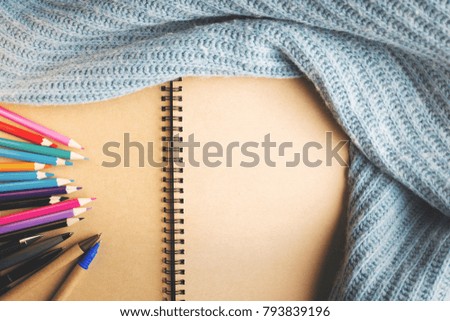 Close up of clean spiral notepad wrapped in knitted cloth. Cozy workplace concept. Mock up