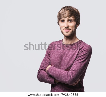 Handsome smiling young man studio portrait. Cheerful men on gray background, isolated.