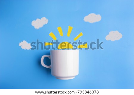 sun and white cup on blue background. good morning concept Royalty-Free Stock Photo #793846078