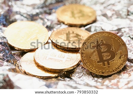 Golden bitcoin coin on silver background.