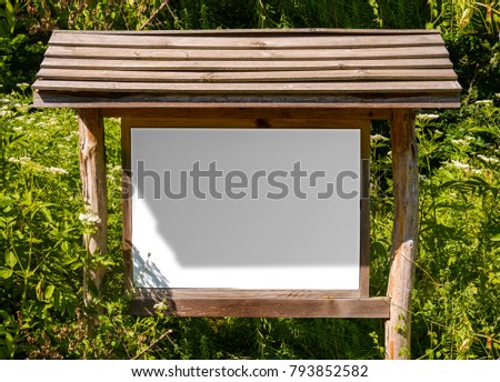 A blank white board in a forest for information ,sign for advertising with shadows.