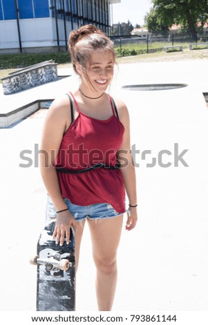 Stylish little girl child with skateboard over urban background