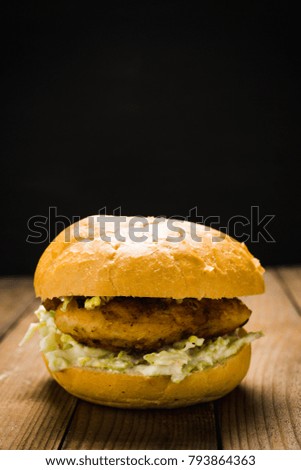 Burger on the black wooden background. Selective focus.