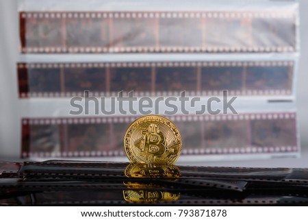 Bitcoin cryptocurrency over Exposed and Developed old film negative strips background.