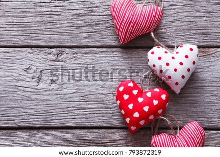 Valentine background with diy sewed pillow hearts bunch on clothespins at rustic gray wood planks, copy space. Valentine's Day, love, romantic concept. Horizontal orientation