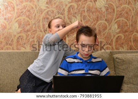 Two kids looking at notebook - laying flat on the floor