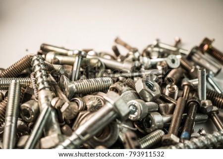 Screws close up, bunch of screws on white background, low angle close up