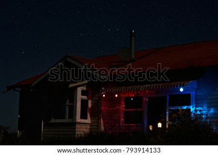A farm house under clear starry night sky in rural New Zealand. Northland region, summer