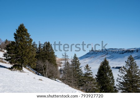 View to the antenna tower of Chasseral in swiss Jura, covered with snow.