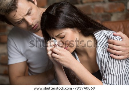 Young man comforting crying sad woman, caring friend consoling upset girl in tears, loving husband helping wife overcome problems or grief, compassion, empathy and support in relationships concept Royalty-Free Stock Photo #793940869