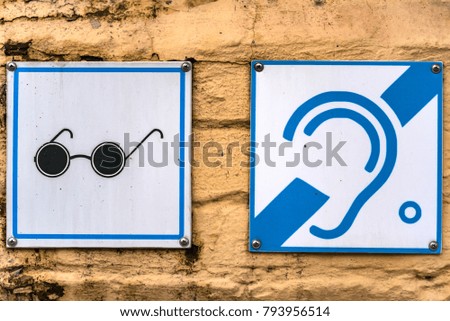 Visual and hearing disability signs on wall