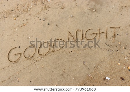 Handwriting  words "GOODNIGHT" on sand of beach.
