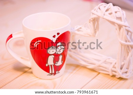 Concept of St.Valentine's Day, Love, Anniversary, Wedding with a white porcelian mug decorated with a heart image and I Love You inscription on a wooden table