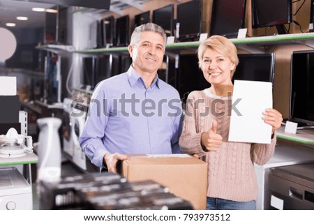 Smiling mature married couple are happy buying on credit household appliances for home