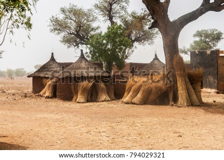 Traditional domestic huts in a african mosi village of Burkina Faso with some bundles of straw against their circular walls. Royalty-Free Stock Photo #794029321
