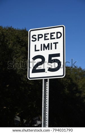 25 mph speed limit sign blue sky trees sunny