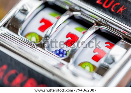 Gambling slot machine in close up view on money background.   Royalty-Free Stock Photo #794062087