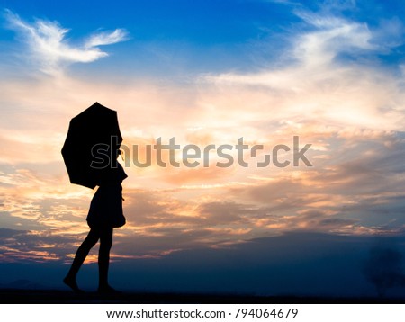 Silhouette a happy young woman with umbrella at twilight time