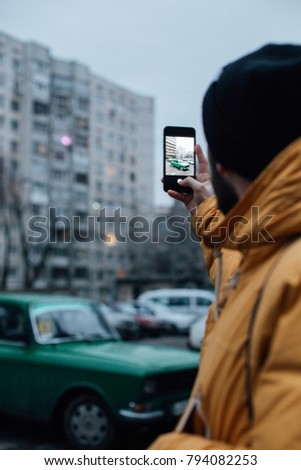 Social media influencer or mobile photographer makes photo of old vintage car on smartphone. internet and technology addiction