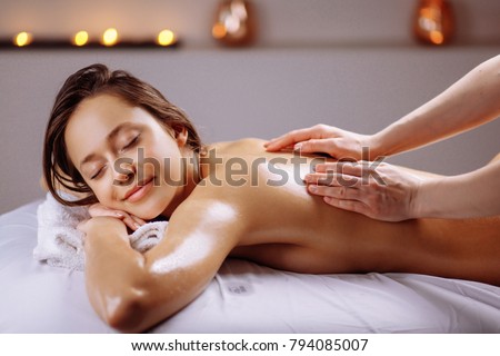 Beautiful woman receiving a relaxing back massage at spa. Royalty-Free Stock Photo #794085007