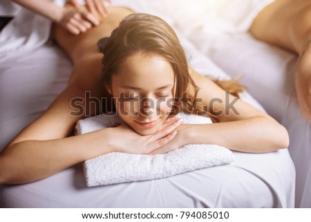 Beautiful woman receiving a relaxing back massage at spa. Royalty-Free Stock Photo #794085010