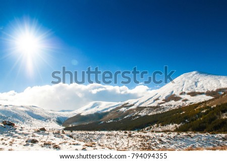 Mt. Erciyes volcano covered with snow  against the sun in winter, on a clear sky day