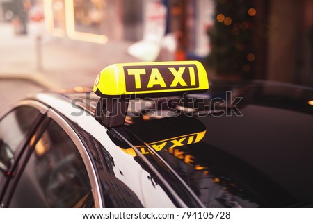 yellow taxi car roof sign at night. taxi car on the street at night. selective focused image. Royalty-Free Stock Photo #794105728