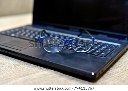 Eye Glasses on Businessman Wooden Table with Other Stuffs - Keyboard, Notebook, Pen and Phone.Office workplace with laptop , smart phone ,businessman work in Office desk,selective focus ,vintage tone