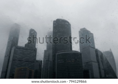 View of buildings through windshield of car during rain