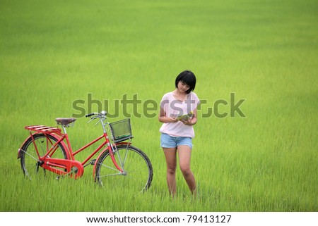 girl reading a book in paddy field.