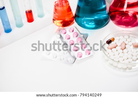 pills and test tubes in laboratory. drug discovery, pharmacology and biotechnology concept. science and medical research background with copy space.