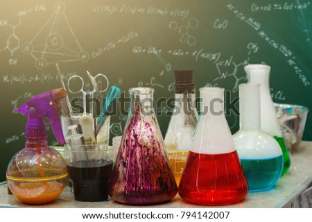 colored reagents in laboratory flasks Chemistry lab set with colored chemicals in it on a table over blue background glassware and